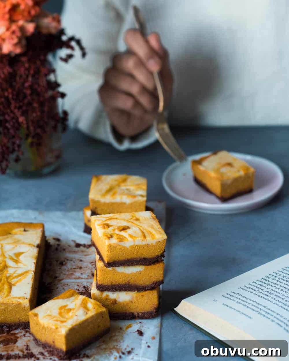 Vegan Baked Pumpkin Cheesecake Bars — Creamy Fall Dessert 7 Woman eating cheesecake bar on a plate with fork.