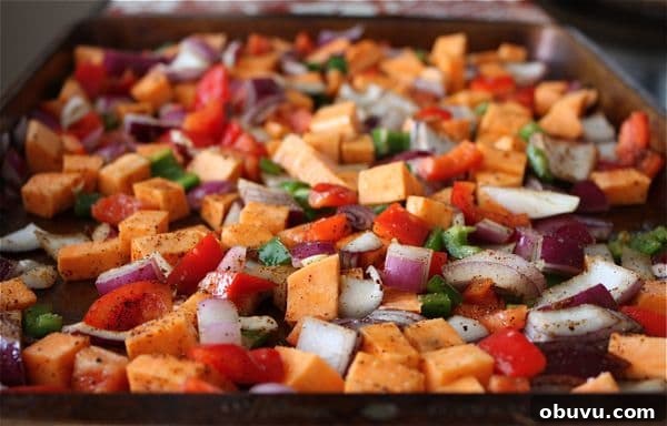 Savory sweet Roasted Veggie and Black Bean Burritos are a delicious vegetarian meal even meat lovers will enjoy! sheet pan of sweet potatoes and vegetables ready to be roasted