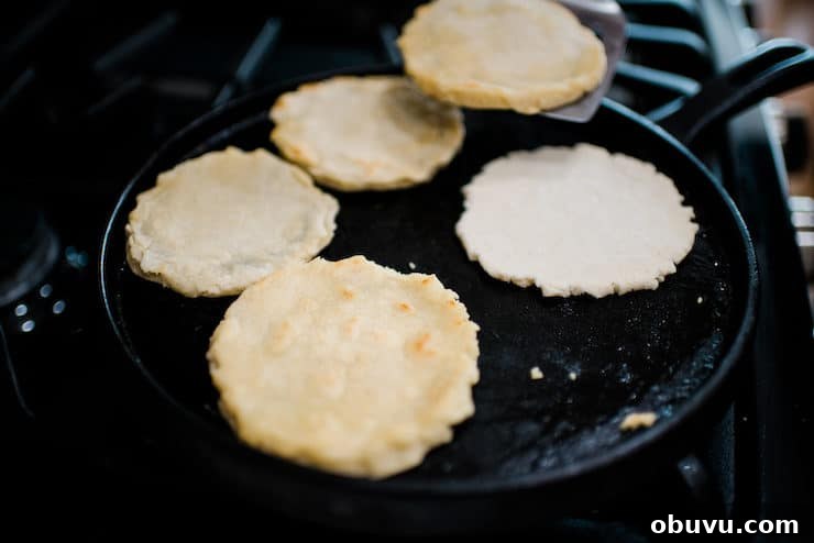 Brisket Sopes: Authentic Mexican Sopes de Carne Deshebrada 8 Cooking sopes on a cast iron griddle.