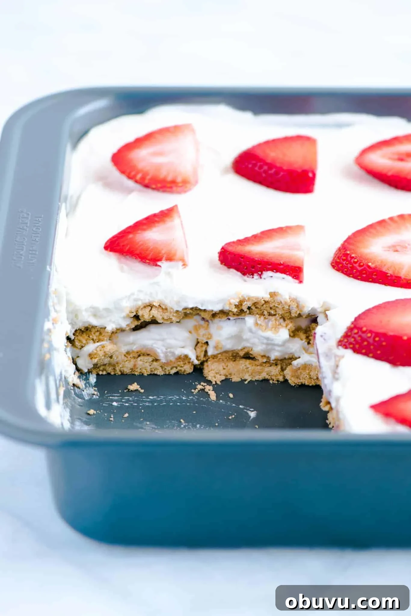 Gluten-Free Strawberry Icebox Cake Recipe for Summer Slices 5 Gluten Free Strawberry Icebox Cake in a metal pan with a slice cut out