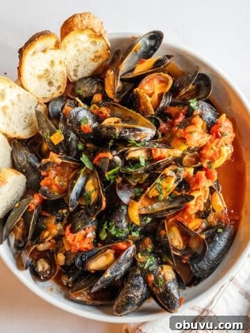 Mussels Fra Diavolo in a serving bowl with crostini.