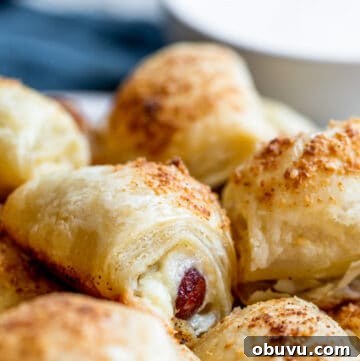 Cheesy Puff Pastry Pigs in a Blanket Recipe 11 Strait on shot of pigs in a blanket on platter.
