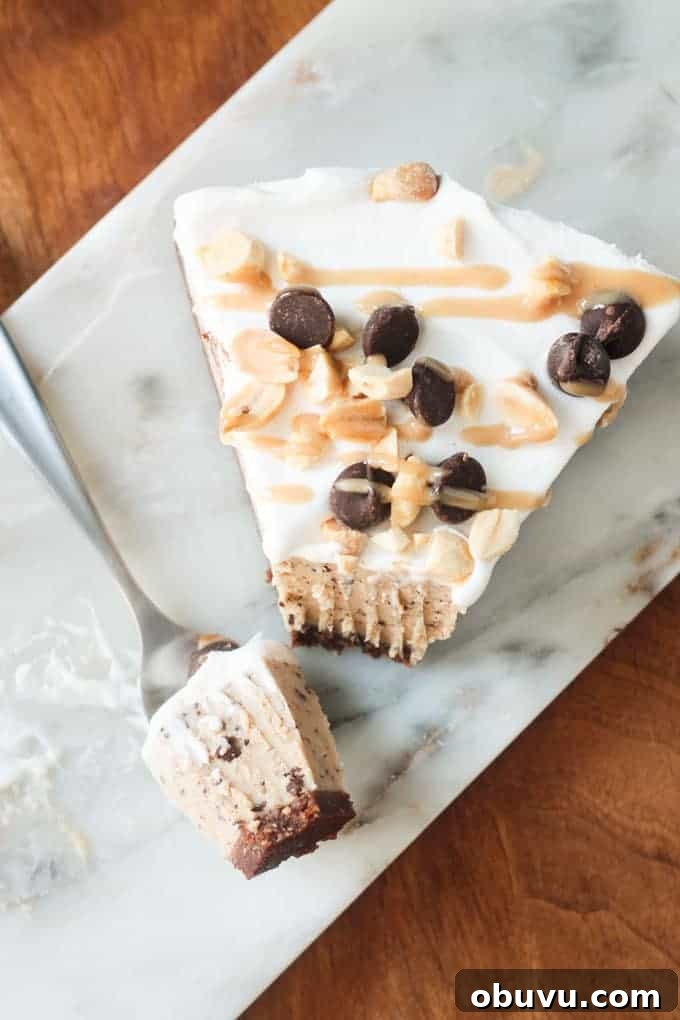 Frozen Peanut Butter Chocolate Chip Pie Fork holding one bite of frozen dessert pie next to the rest of the slice of pie