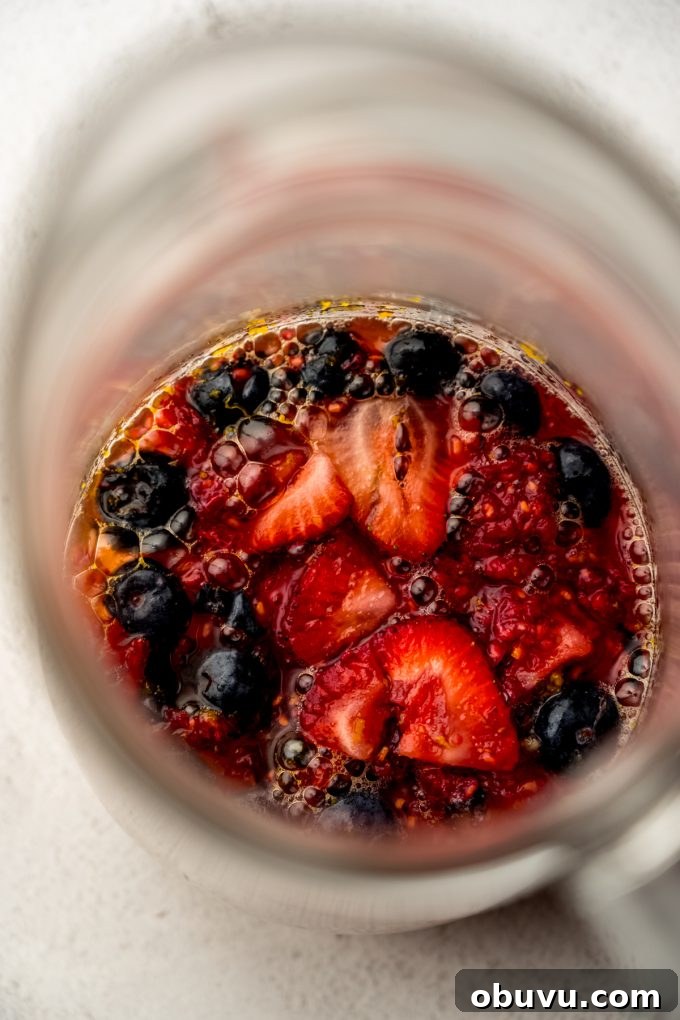 Berry Sangria and Berry Mocktail Recipes for Every Occasion 11 Aerial photo of the fruit mixture for berry sangria in a glass pitcher.