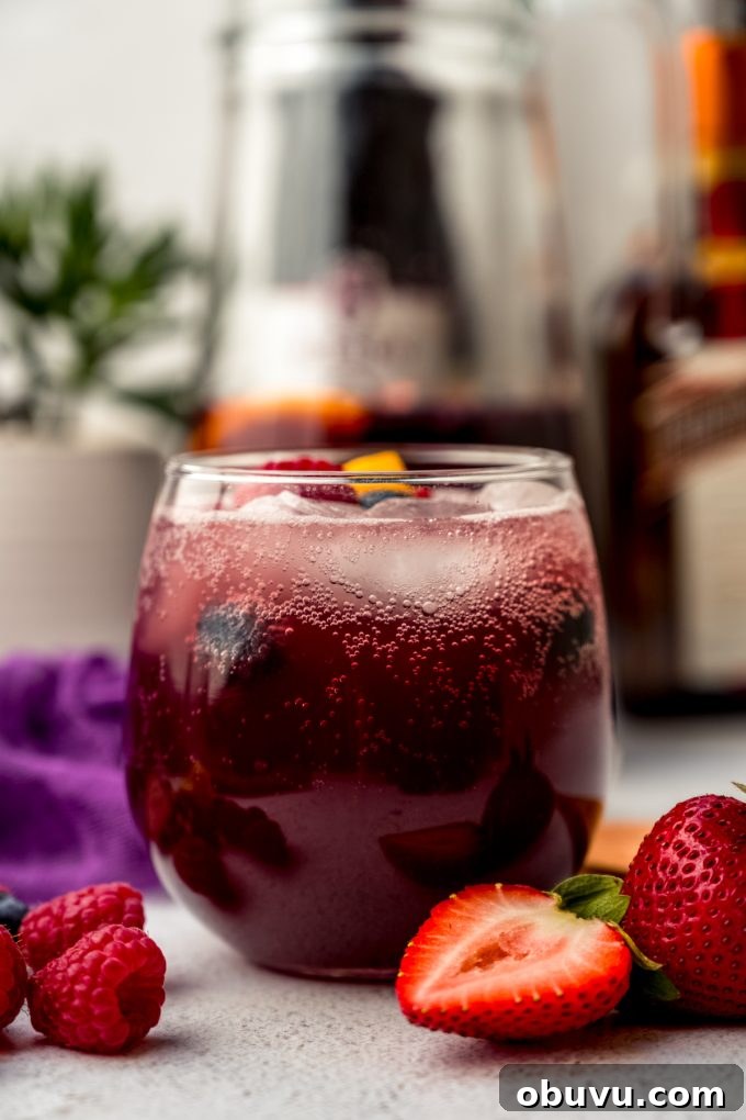 Berry Sangria and Berry Mocktail Recipes for Every Occasion 15 A glass of berry sangria on a surface.