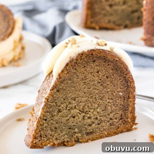 Moist Banana Bundt Cake Recipe for Perfectly Tender Loaf 6 A slice of banana bundt cake with cream cheese frosting on a white plate.