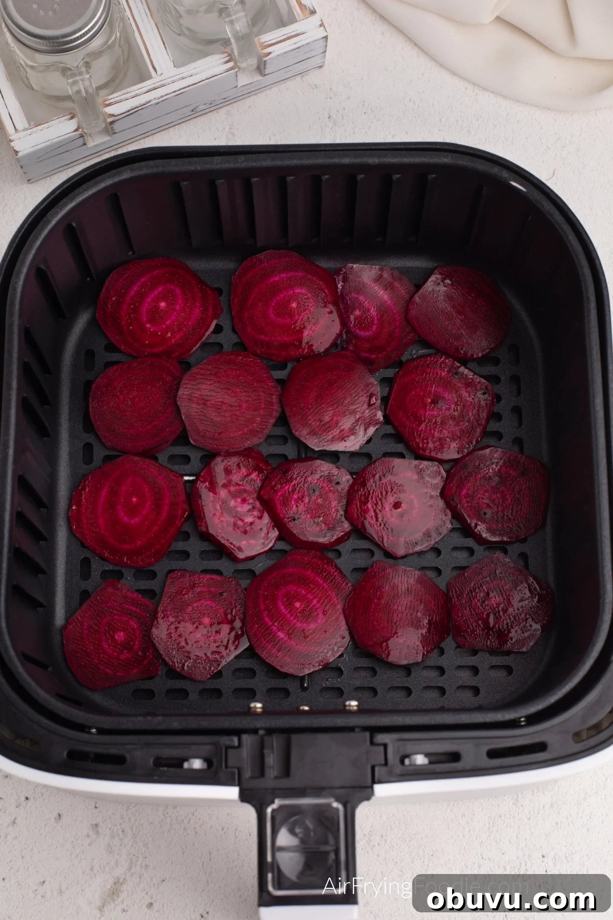 Crispy Air Fryer Beet Chips Recipe: Quick Homemade Snack 6 Sliced beets placed in a single layer in the basket of the air fryer.