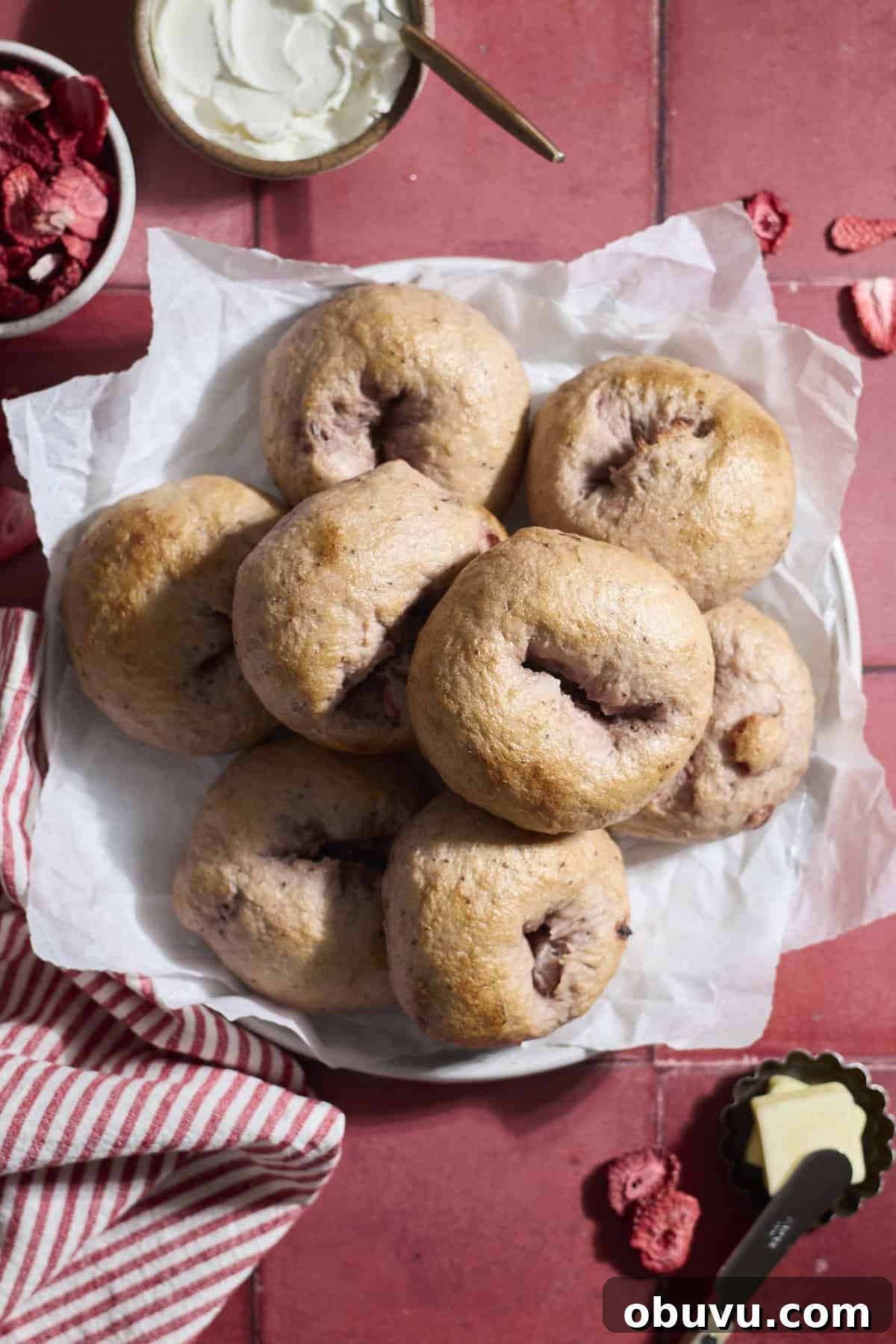 Strawberry Sourdough Discard Bagels: Soft, Tangy & Fresh 2 Sourdough Discard Strawberry Bagels on a white platter.