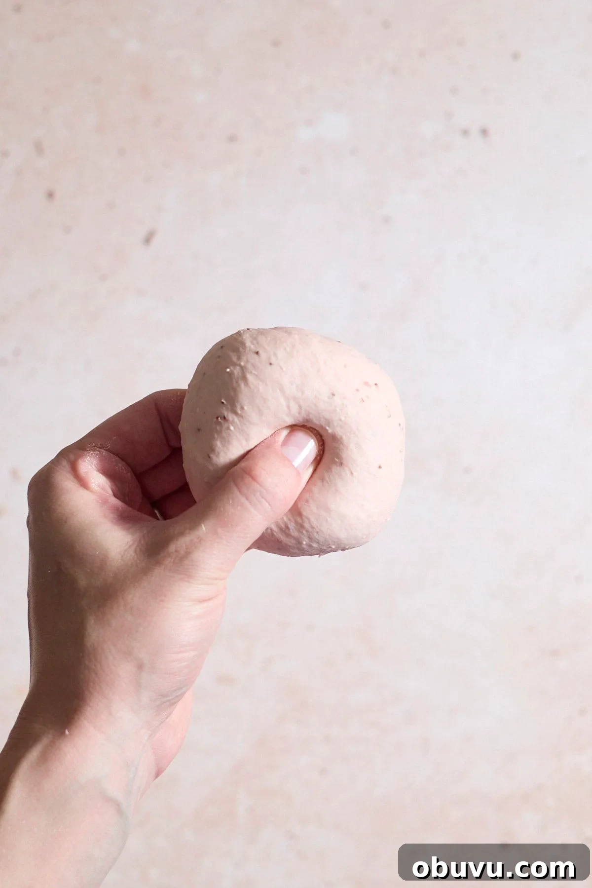 Strawberry Sourdough Discard Bagels: Soft, Tangy & Fresh 9 A thumb pressing a hole in the center of the bagel.