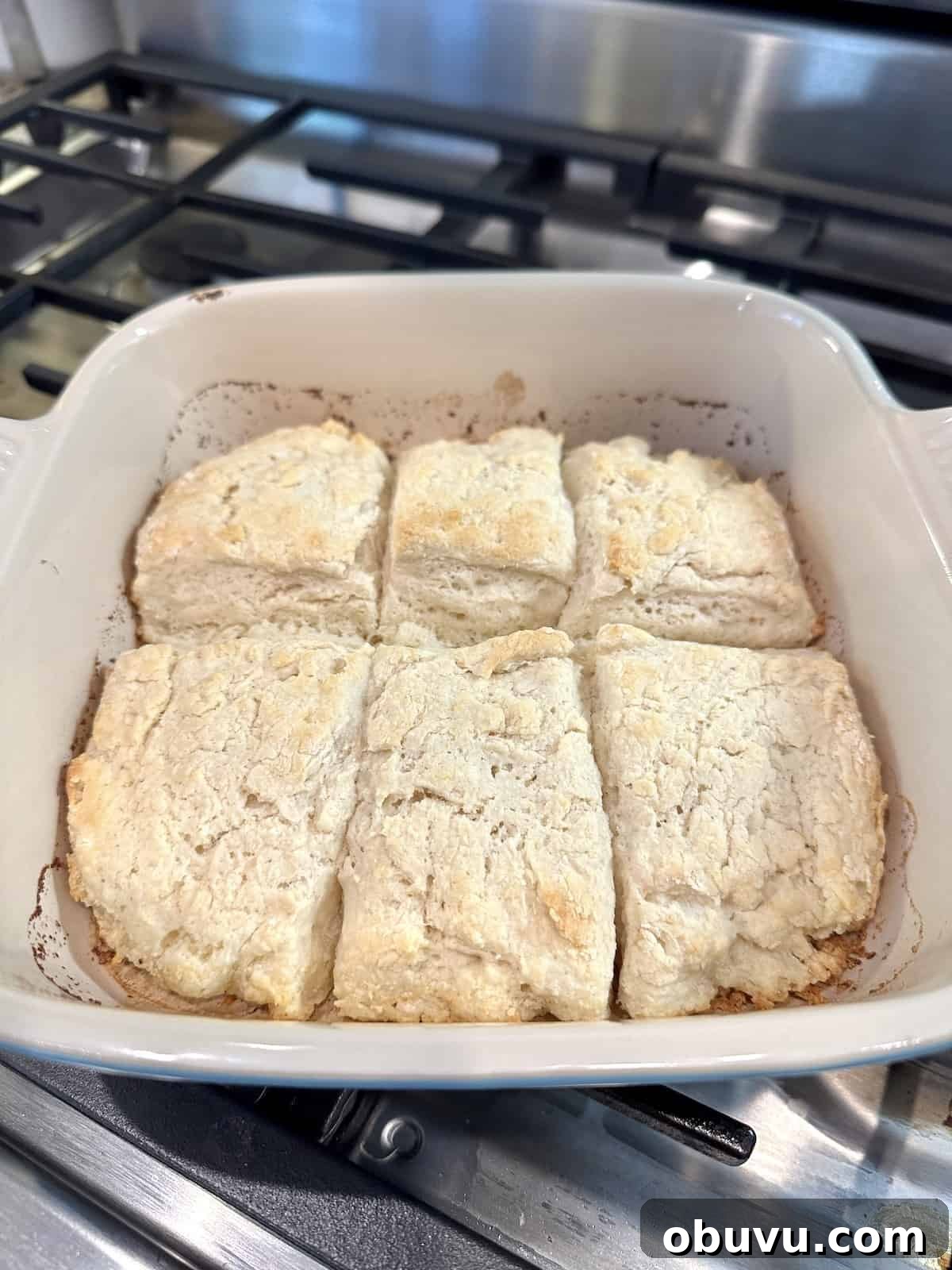 Flaky Buttermilk Biscuits Recipe for Perfect Homemade Biscuits 6 Baked biscuits in a small baking dish on the stovetop.