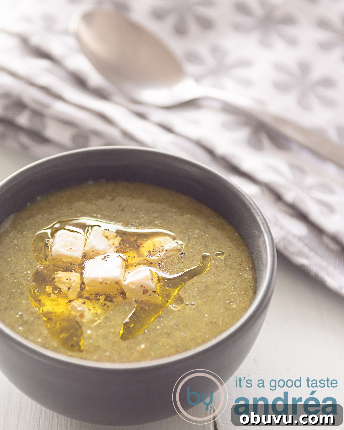 Creamy Vegan Spinach and Potato Soup Recipe 5 spinach soup in a grey bowl on a white background. A grey white towel left top.
