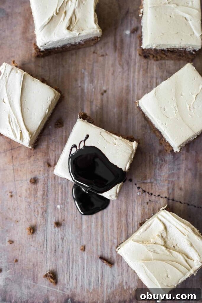 Slices of Sticky Date Cake on a wooden board with a drizzle of black treacle.