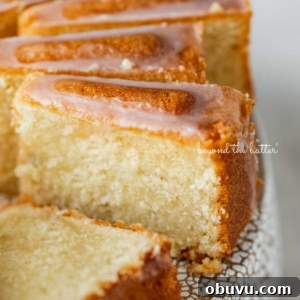 Lemon Cream Cheese Pound Cake Recipe with Zesty Glaze 14 Sliced lemon cream cheese pound cake with a lemon glaze on a cake stand.