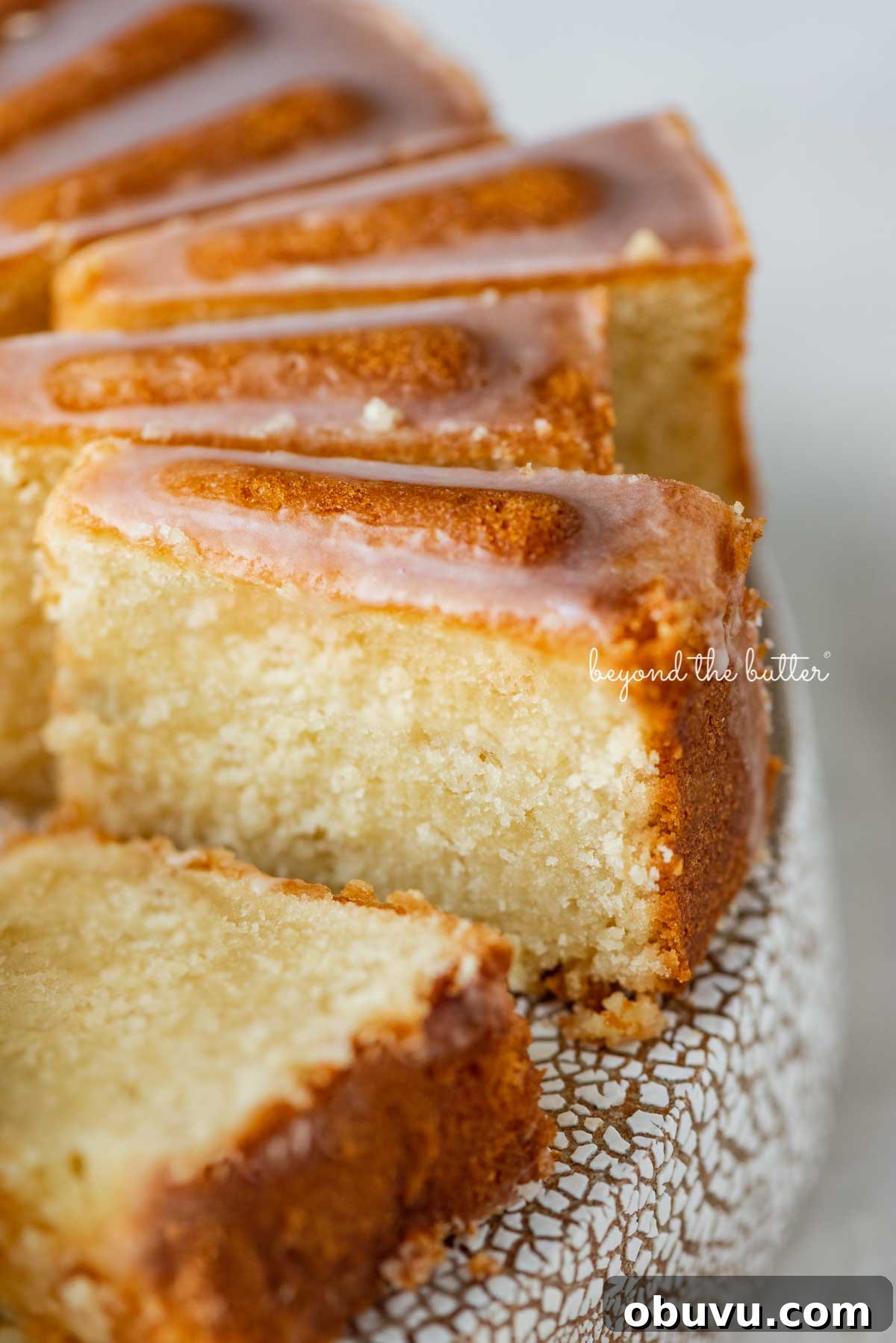 Lemon Cream Cheese Pound Cake Recipe with Zesty Glaze 4 Sliced lemon cream cheese pound cake with a lemon glaze on a cake stand