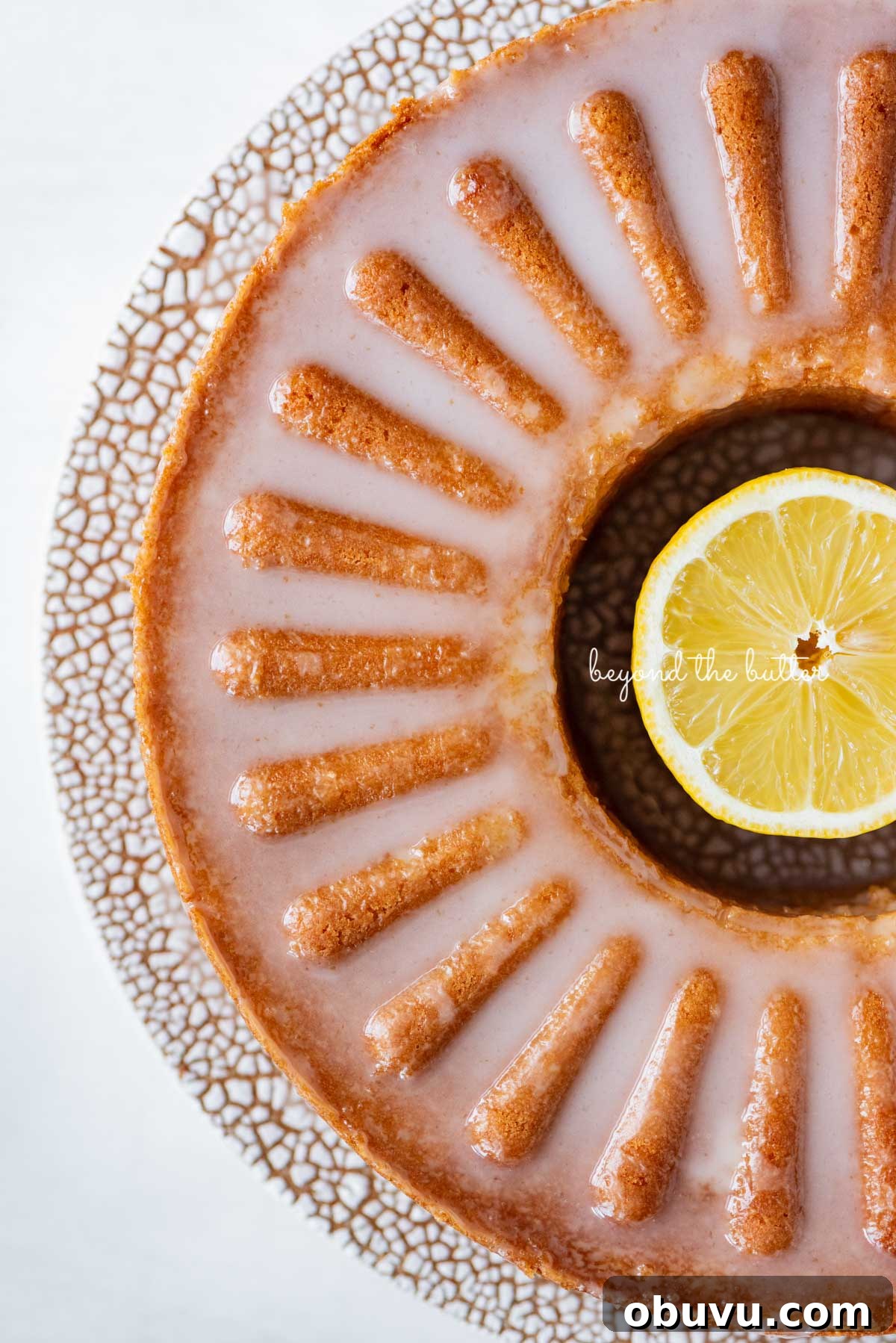 Lemon Cream Cheese Pound Cake Recipe with Zesty Glaze 7 Glazed lemon cream cheese pound cake on a ceramic cake stand