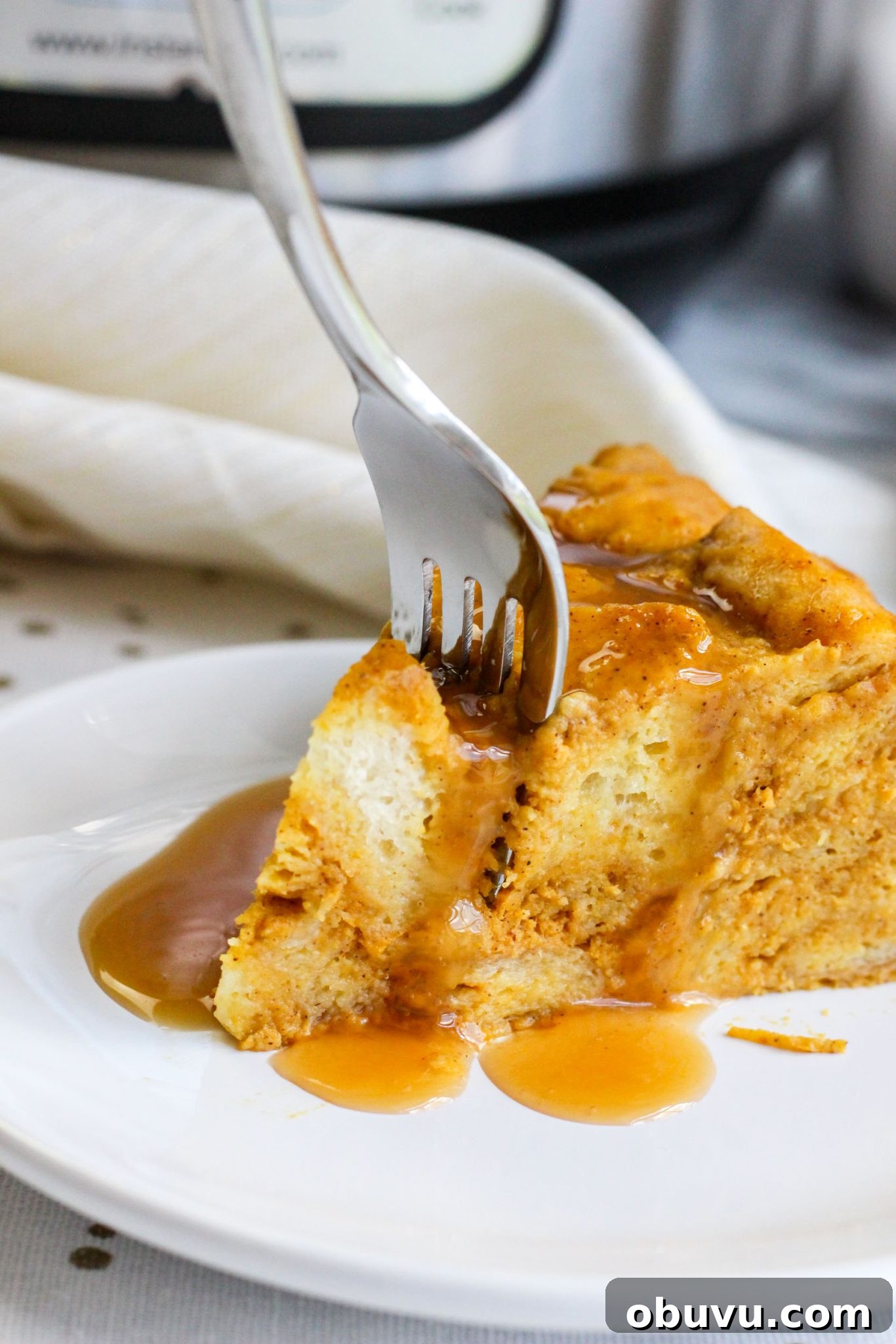 Instant Pot Pumpkin Bread Pudding with Air Fryer Crisp Option 8 A fork stuck into a slice of punkin pie bread pudding.