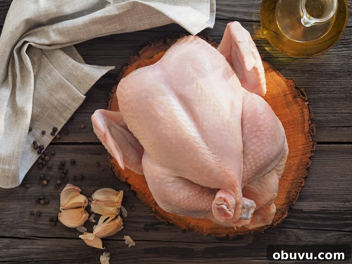 Smoked Whole Chicken Recipe: Juicy, Crispy Skin and Flavorful Smoke 4 Raw roaster chicken on cutting board with garlic and bottle of olive oil