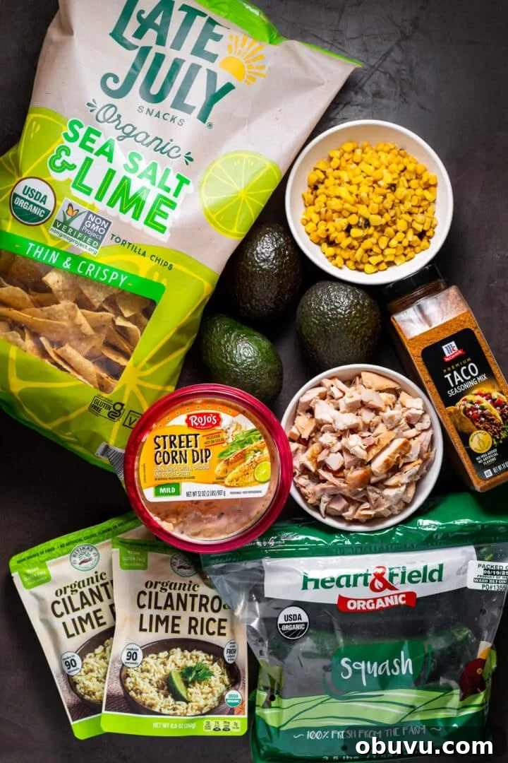 the costco staples needed to make this recipe: street corn dip, squash, cilantro rice packets, frozen corn, tortilla chips and taco seasoning