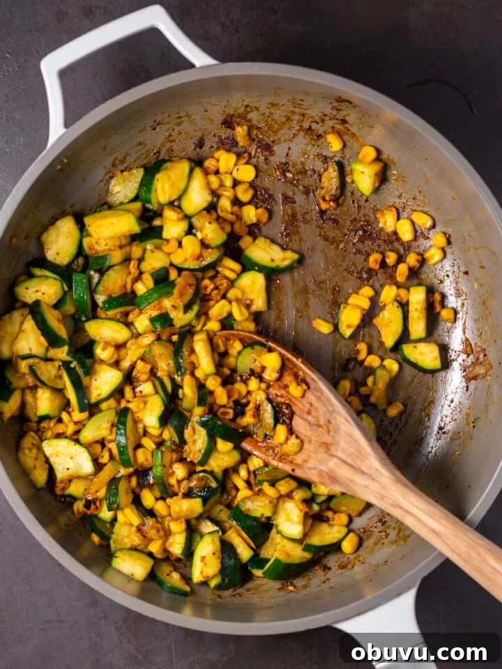 sautéed zucchini and corn seasoned with taco seasoning in a skillet