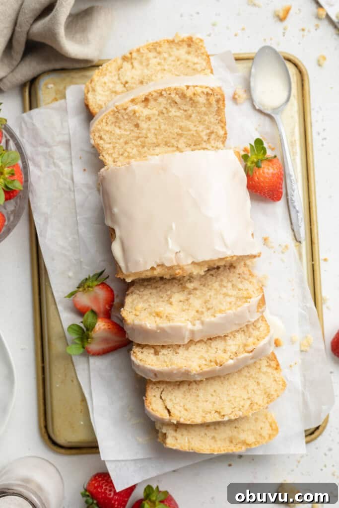 Ultimate Vegan Pound Cake Recipe You’ll Love 2 overhead image of vegan pound cake sliced on both ends, with fresh strawberries on the side