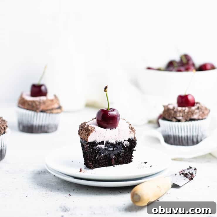 chocolate cherry cupcake cut in half to reveal cherry filling.