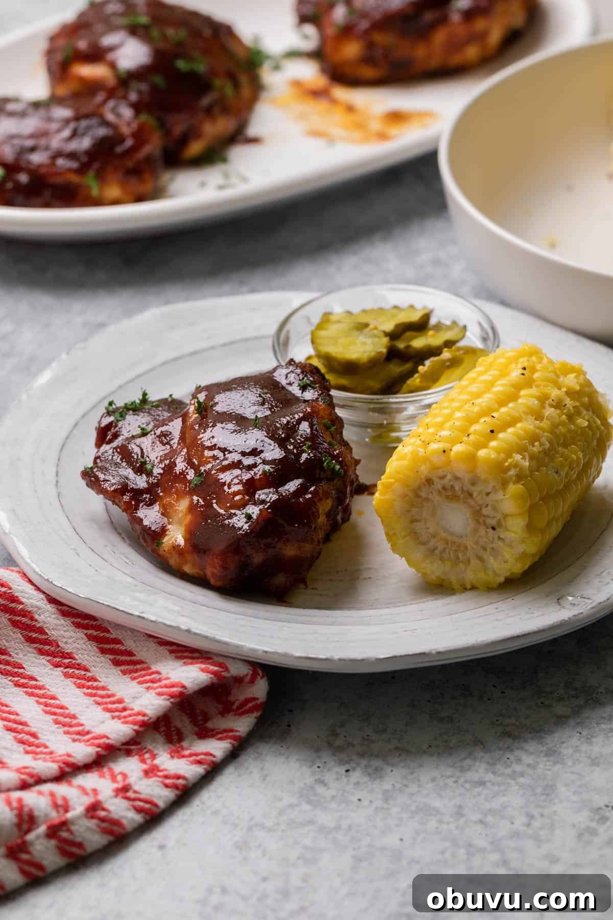 Crispy Air Fryer BBQ Chicken Thighs in 20 Minutes 2 the completed air fryer bbq chicken on a plate with corn