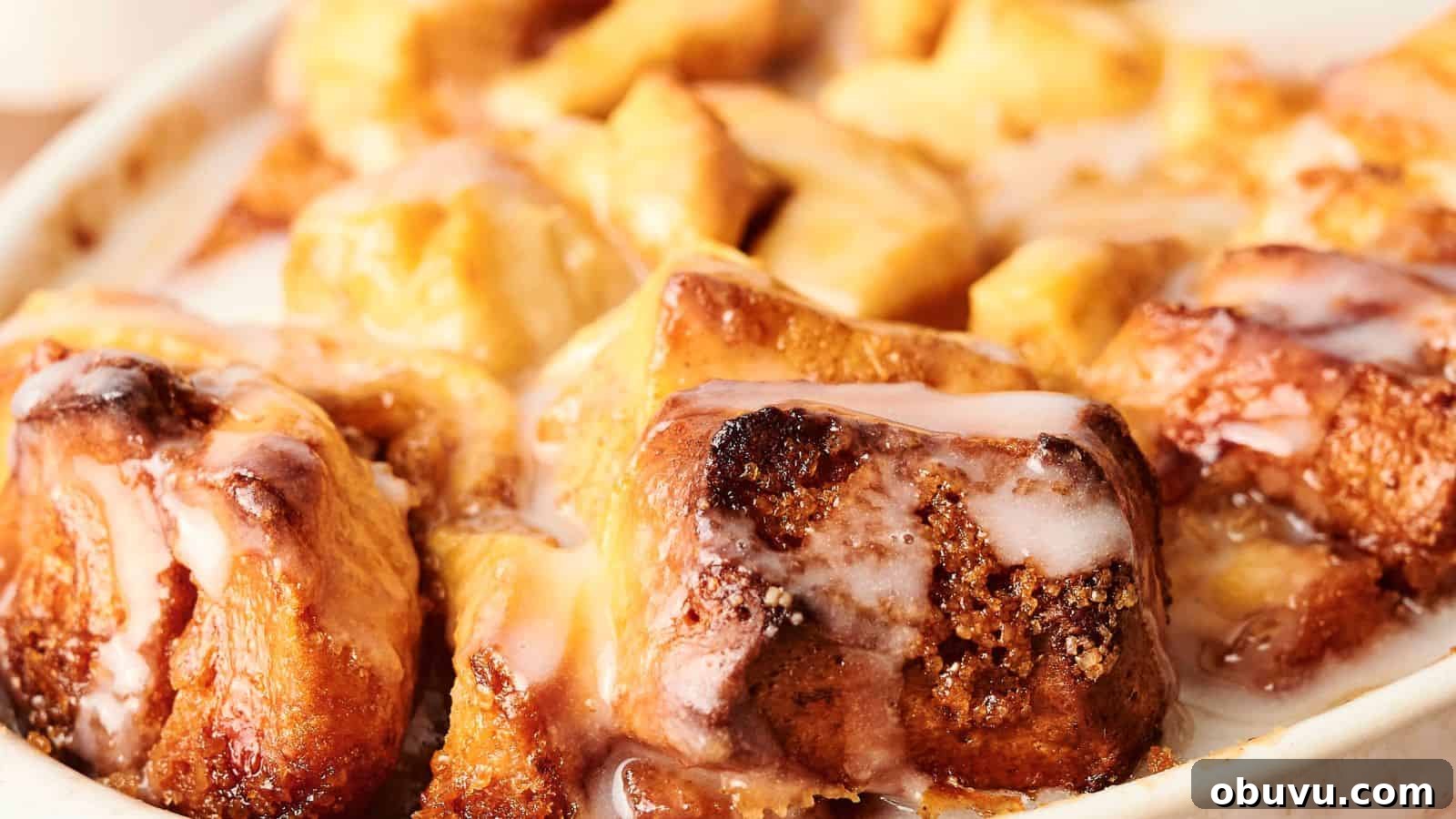 Close-up of a dish of warm cinnamon rolls topped with white glaze.