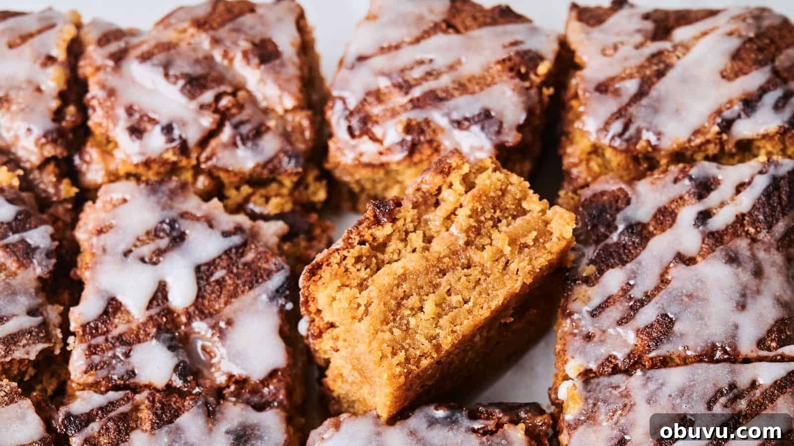 Close-up of sliced crumbly cakes topped with white icing. One piece is positioned vertically to show its texture.