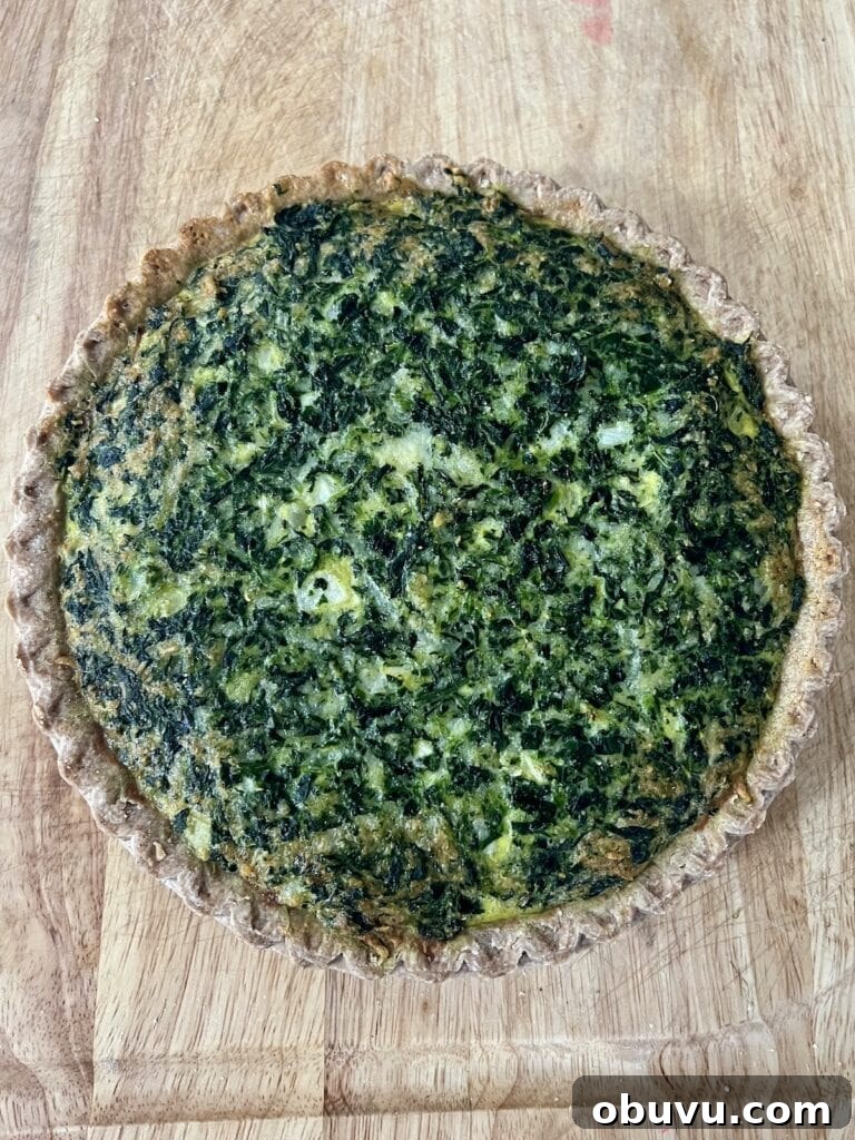 Spinach and Swiss Quiche with Frozen Pie Crust 8 Finished spinach quiche recipe on cutting board.