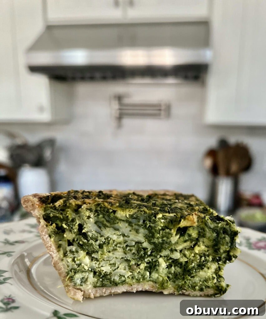 Spinach and Swiss Quiche with Frozen Pie Crust 12 Slice of easy spinach quiche with frozen pie crust on plate with stove and kitchen in background.