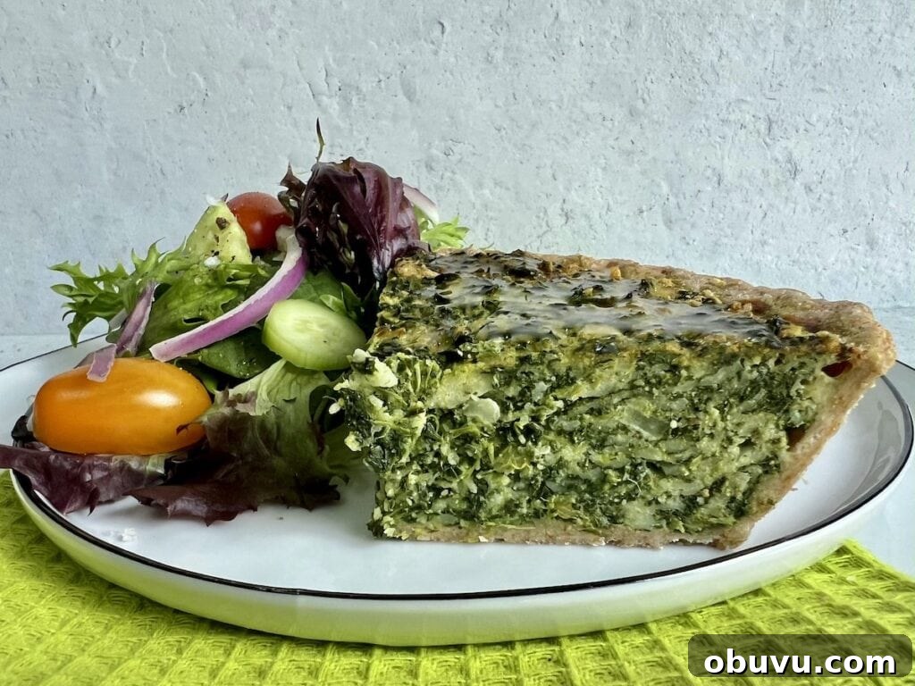 Spinach and Swiss Quiche with Frozen Pie Crust 3 Beautiful slice of spinach swiss quiche with mixed salad on white plate on decorative green towel.