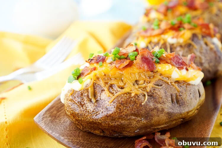 These are the Best Ever Baked Potatoes, they're perfectly seasoned and loaded up with a creamy dressing, cheddar cheese, bacon, and chives!