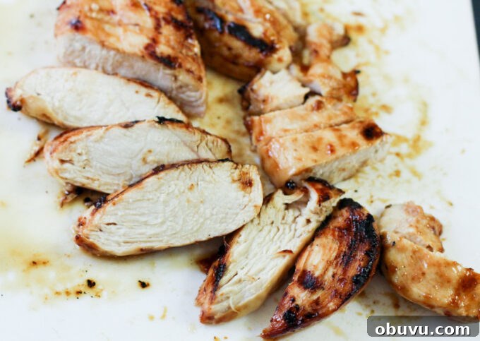 General Tso Grilled Chicken Bowls with Sesame Rice 6 sliced grilled chicken on a white plate.