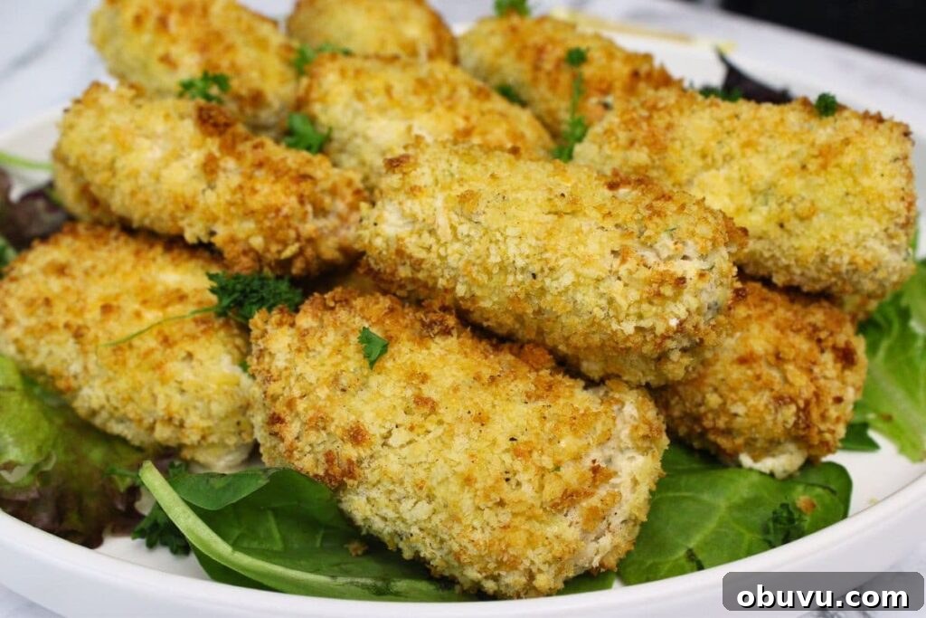 Crispy Air Fryer Chicken Croquettes Made from Leftovers 13 closeup view of air fryer chicken croquettes on a plate of greens
