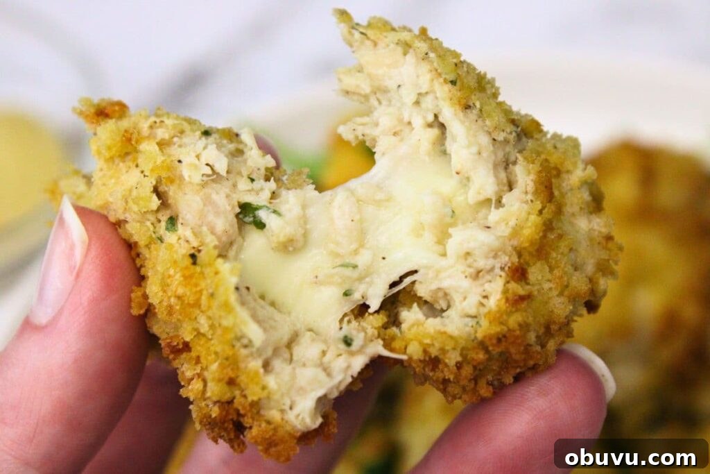 Crispy Air Fryer Chicken Croquettes Made from Leftovers 3 splitting apart an air fryer chicken croquette with a gooey cheese pull