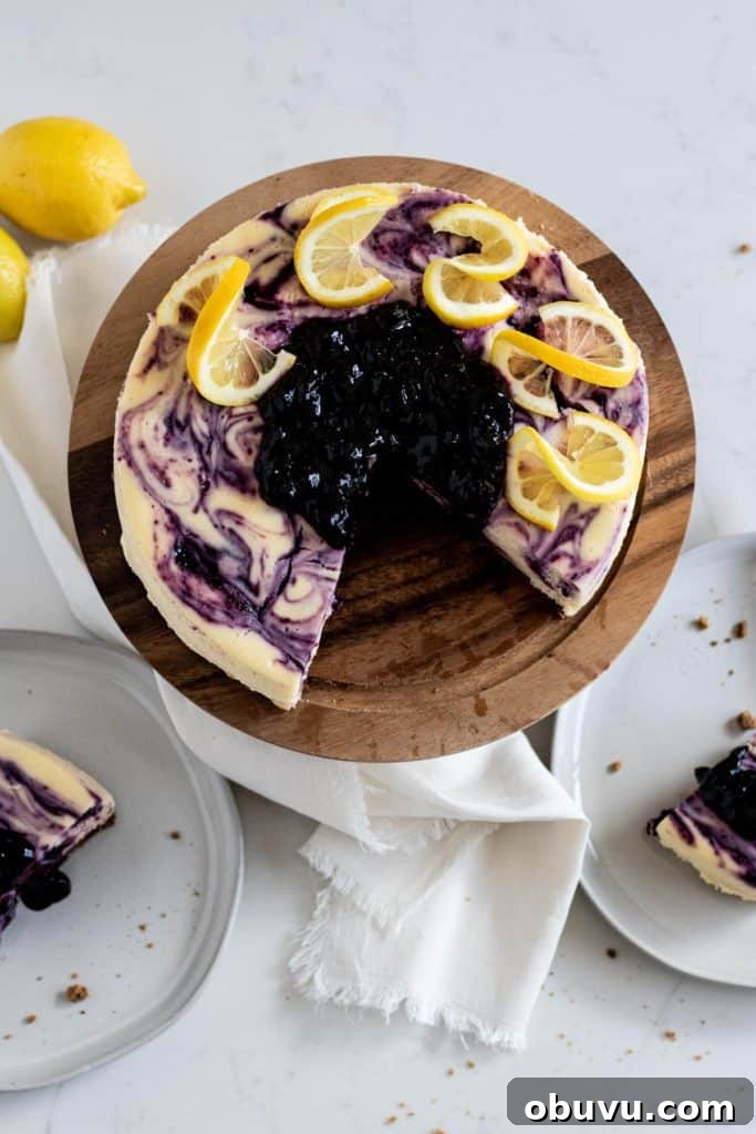 overhead view of whole lemon blueberry cheesecake and slices on a plate