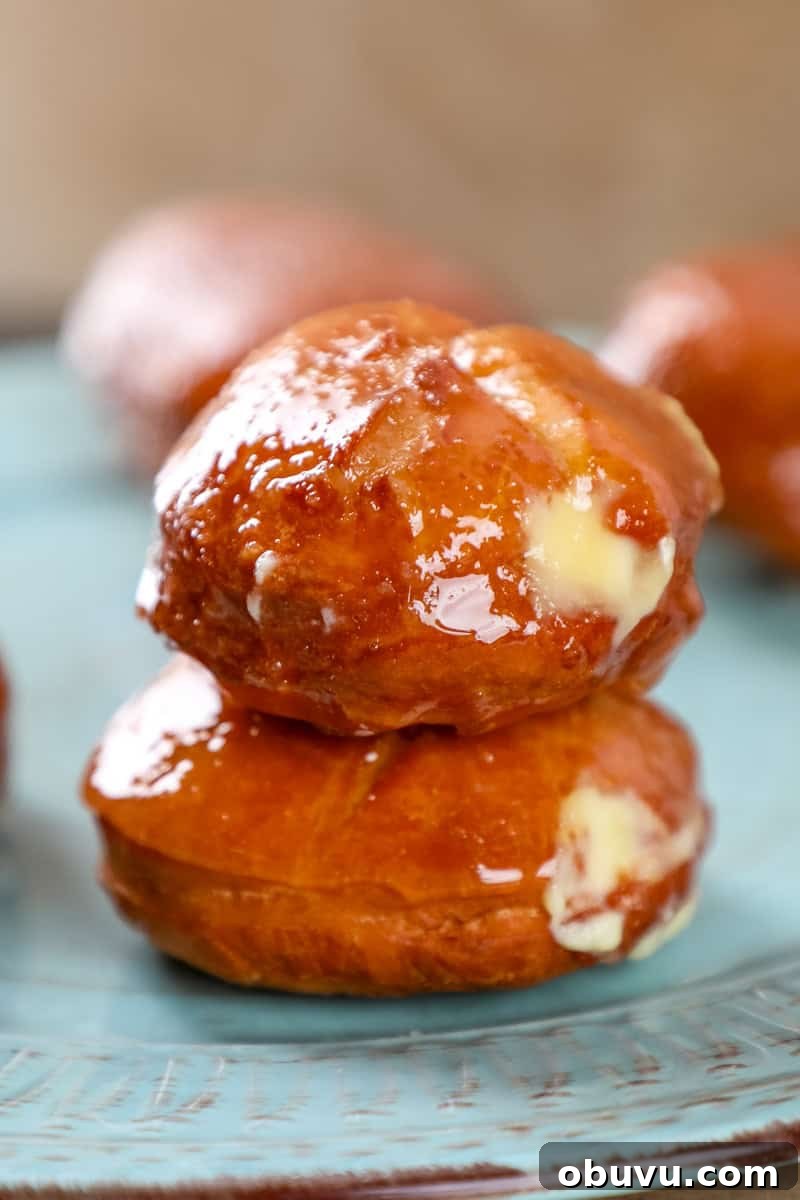 Crème Brûlée-Filled Donuts: Decadent Custard-Packed Treats 2 two creme brulee donuts on top of each other filled with vanilla custard and topped with a crispy caramel shell.
