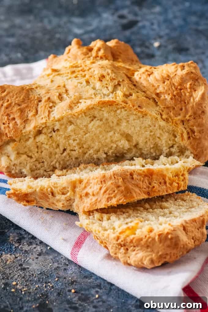 Traditional Irish soda bread on a red and blue striped towel on a blue stone background.