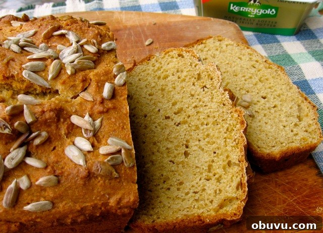 Easy Whole Wheat Soda Bread cut into slices on cutting board with Kerrygold butter in the background.