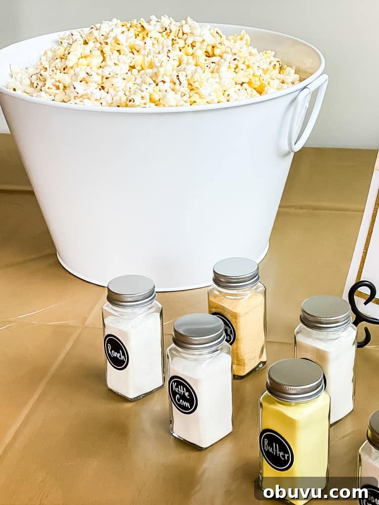 popcorn in large metal bin with small seasoning shakers on table in front of popcorn