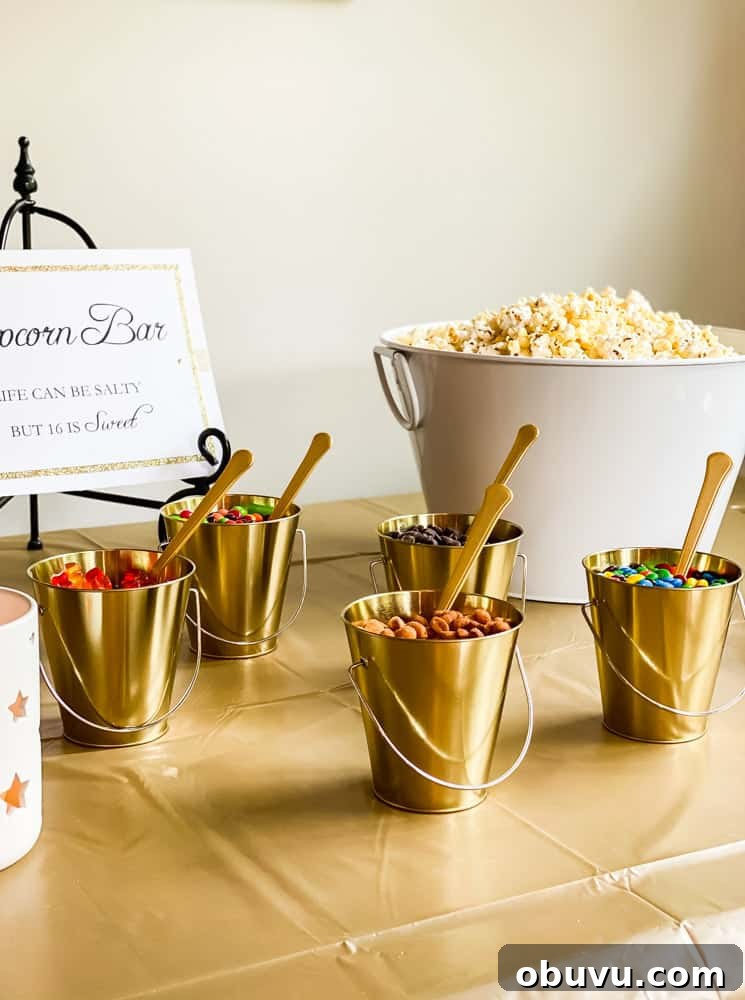 small buckets filled with popcorn toppings and a spoon on table displayed with popcorn bar