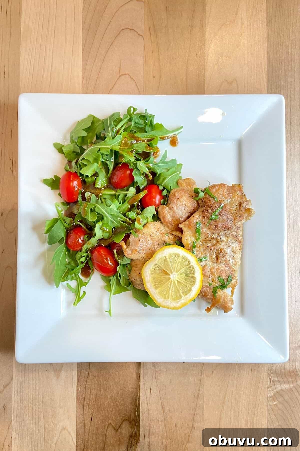 Lemon Scaloppine Recipe: Tender Veal in Zesty Lemon Sauce 8 Served on a white plate with salad.