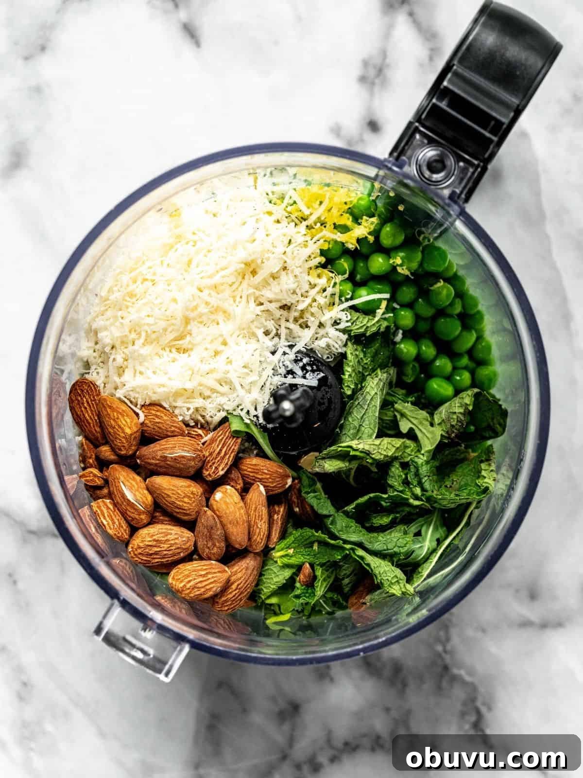 Food processor with peas, mint, almonds, parmesan, lemon zest and juice.