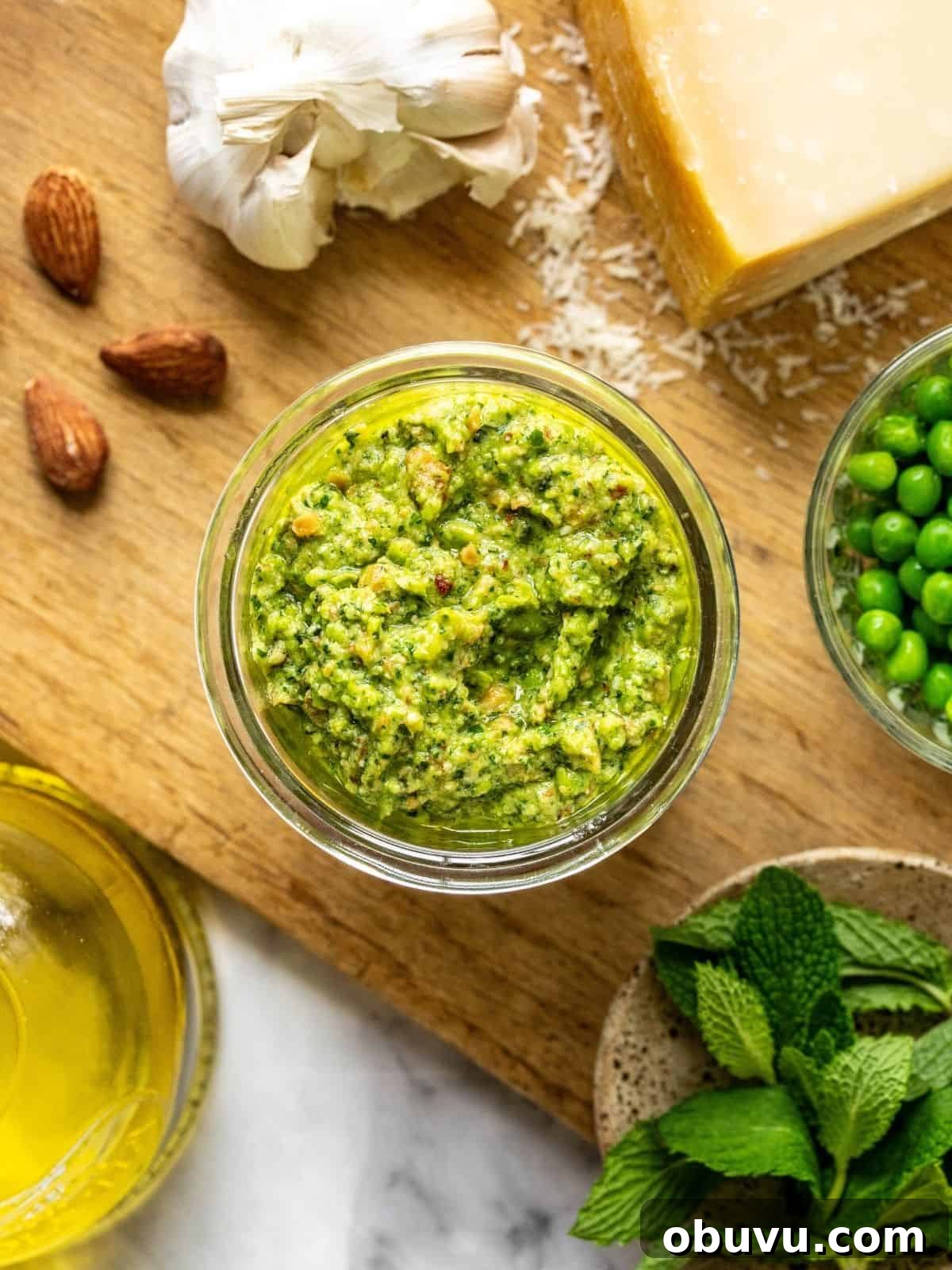 Pea and mint pesto in a mason jar on a wooden board.