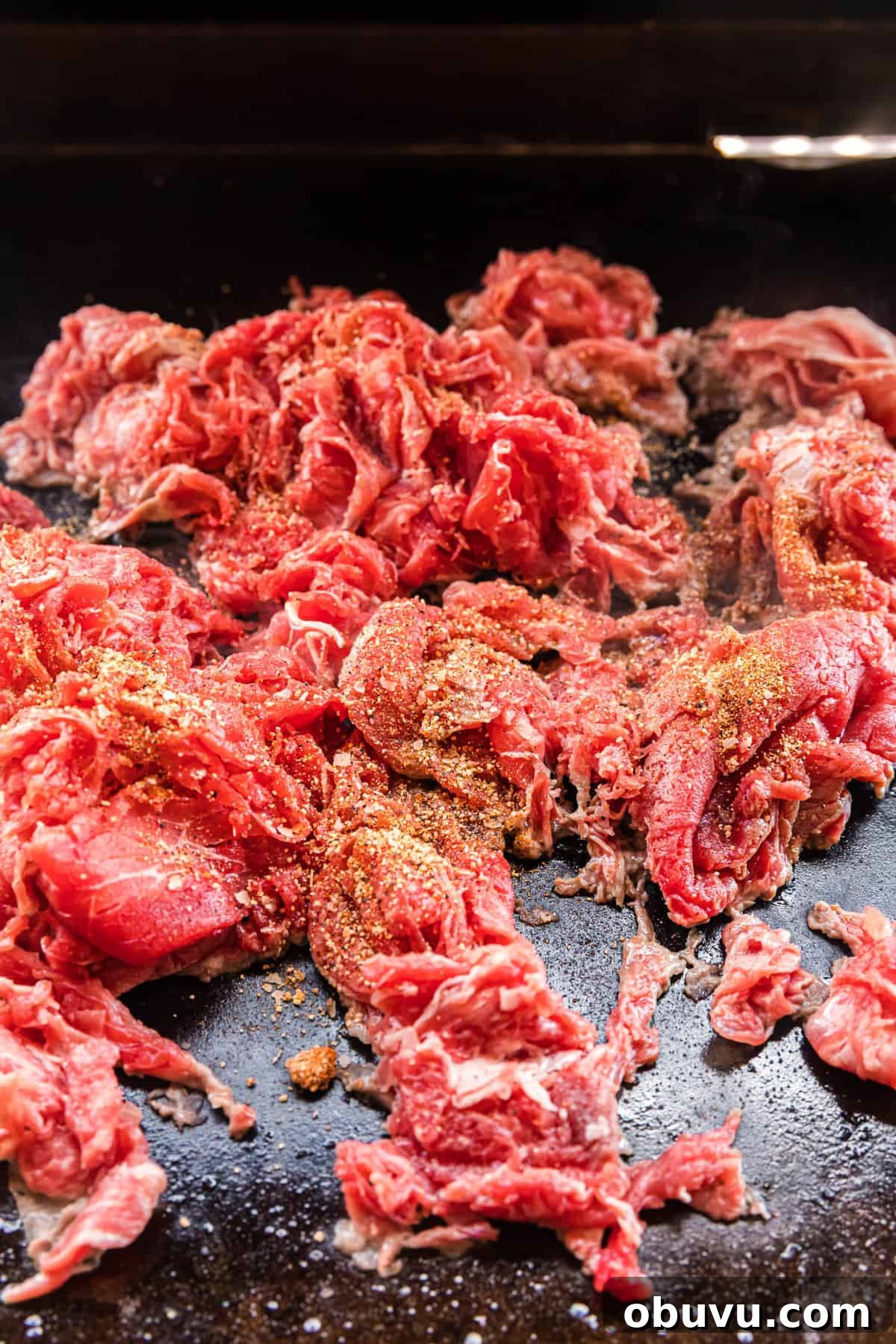How to Make an Authentic Philly Cheesesteak on a Blackstone Griddle 6 Cooking thinly sliced steaks on the hot Blackstone