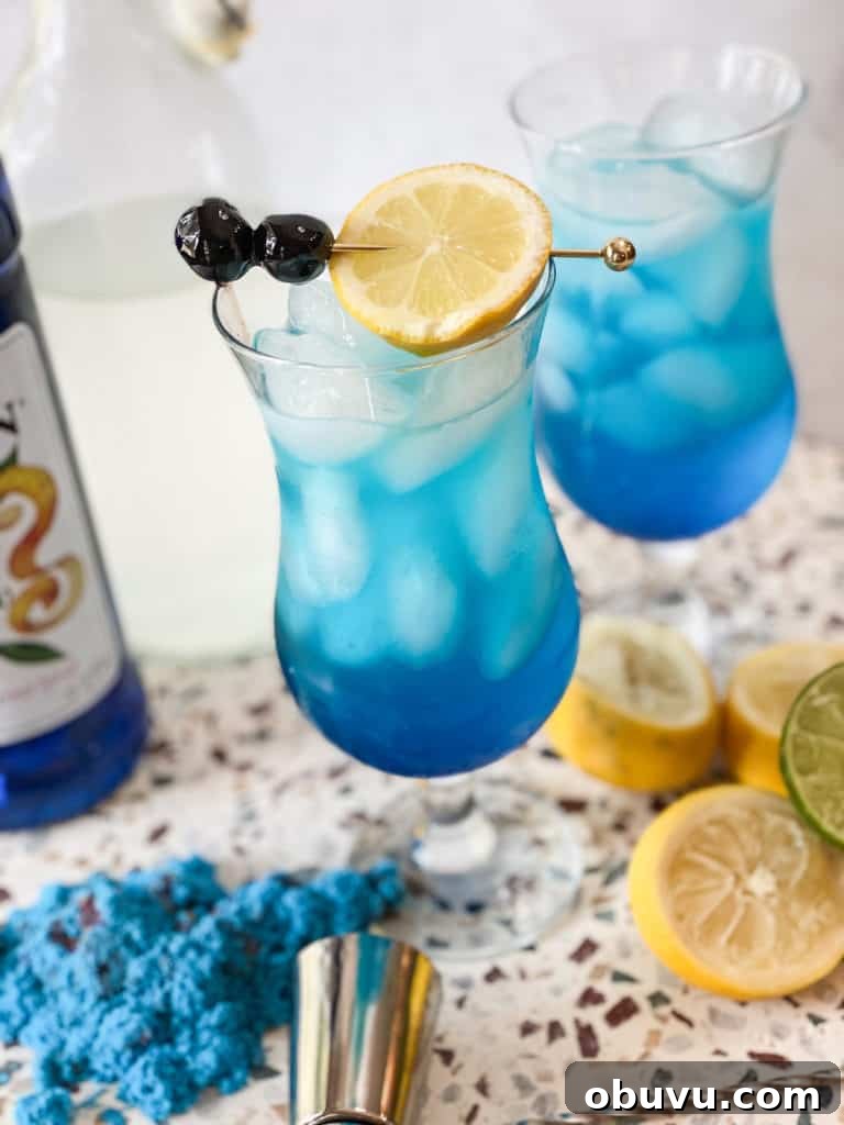 Refreshing 4th of July Cocktails and Festive Mocktails 3 Blue lagoon mocktail in a hurricane glass with lemon and cherries