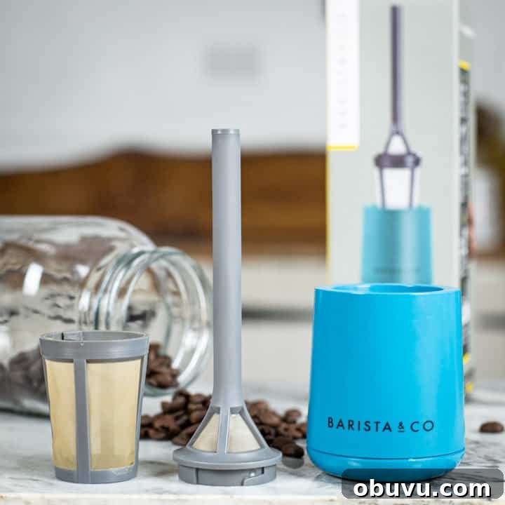 Brew It Stick Review — Is This the Ultimate Camping Coffee Maker? 5 grey and blue plastic camping coffee maker laid out on marble surface with coffee beans and glass jar