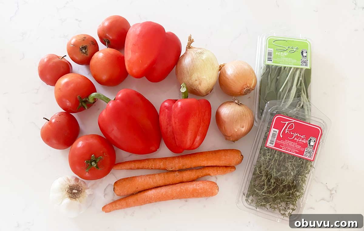Roasted Red Pepper and Tomato Soup Recipe — Cozy Weeknight Dinner 3 A white kitchen countertop with tomatoes, red peppers, onions, garlic, carrots, thyme and sage.
