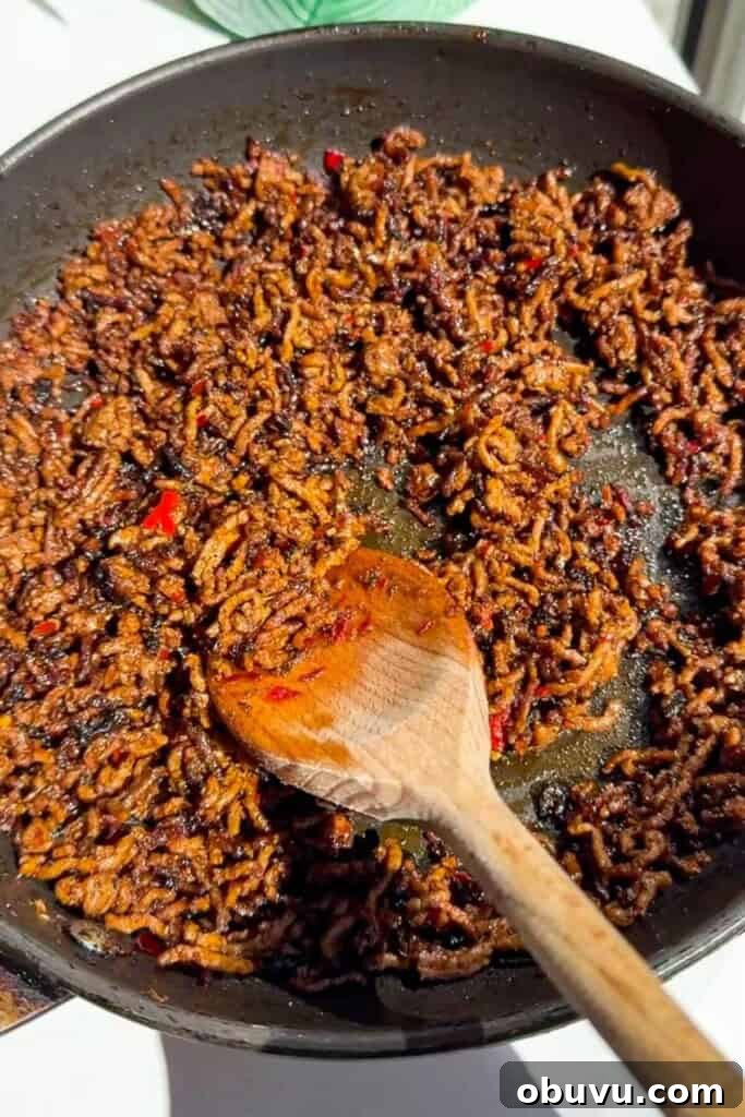 Mediterranean Beef and Rice Bowls with Fresh Herbs 11 Stirring sticky ground beef in pan.