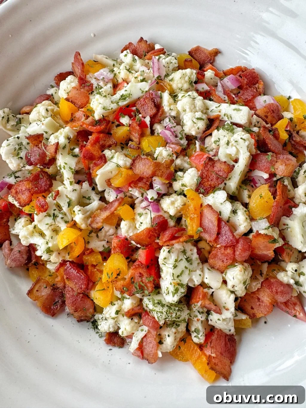 Cauliflower Crunch Salad with Honey Jalapeño Dressing Recipe 2 Cauliflower, chopped bacon, and crunchy vegetables in a white bowl